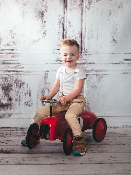 Junge auf rotem Vintageauto, Fotoshooting